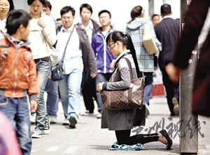 女子背名貴挎包跪地乞討稱只求3元或路費(圖)