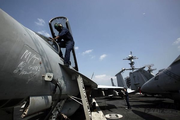 資料圖片：一名機師正在檢修航母上的“大黃蜂”艦載戰(zhàn)斗機。“華盛頓”號航母上共裝載有超過70架艦載飛機。