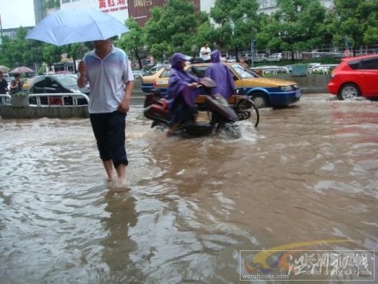 電動車和行人匆匆穿過芙蓉路的引橋，仍然還是要卷起褲腿。　　陳劍岷 攝 圖片來源：星辰在線