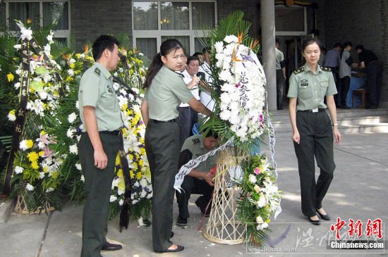 圖為薛明老人家門前送花圈的人們絡(luò)繹不絕。淮黎霞攝影報道