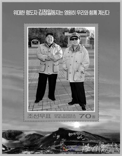30日，朝鮮發(fā)行紀(jì)念金正日的郵票小型張2枚。其中一枚郵票的中央是金正日與金正恩在一起的照片，上端寫著“偉大領(lǐng)導(dǎo)者金正日同志永遠(yuǎn)和我們?cè)谝黄?rdquo;。 新華社發(fā)