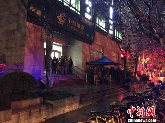 1月5日清晨5點(diǎn)半，在上海靜安郵政支局，市民冒著寒風(fēng)與冷雨，撐傘排隊(duì)，搶購首發(fā)的戊戌狗年生肖郵票。　郭容 攝