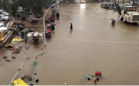 鄭州暴雨過后，人們沿著街道趟過洪水。
